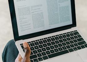 Close-up of a person viewing a document on a laptop screen indoors.