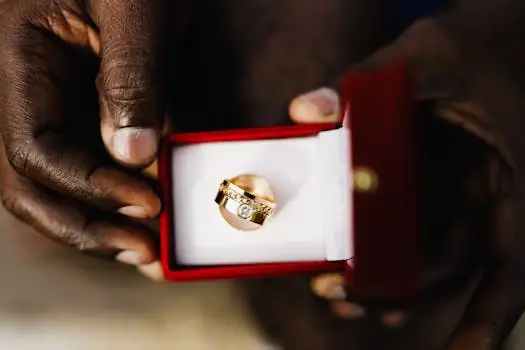 Close-up shot of a diamond ring in a box, held by hands, symbolizing love and commitment.